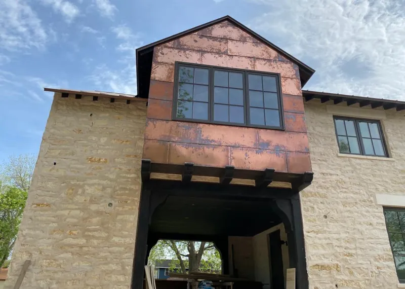 Copper metal panel facade on a stone building for Skylight Installation in Crestview